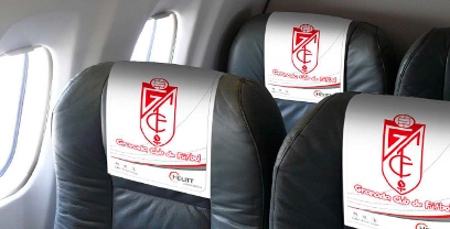 El logotipo del Granada C.F. en los reposacabezas de un avión de Helitt