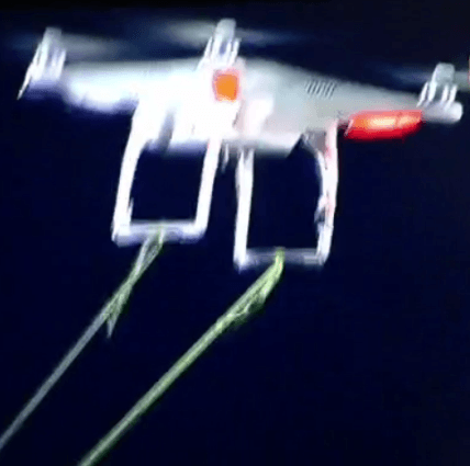 Imagen del drone, del que cuelgan las cuerdas que sujetaban la pancarta