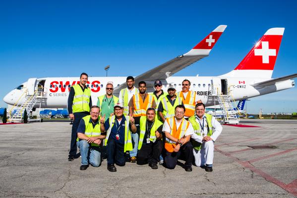 Empleados de Bombardier posan junto al primer CS100 de serie